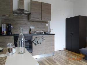 una cocina con una botella de vino en una mesa en Legend- Parking privé Gratuit- Terrasse privée- Wifi - Convert - Alimentec, en Bourg-en-Bresse