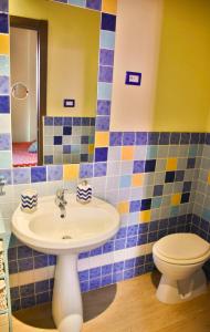 a bathroom with a sink and a toilet at Flowery Inn Villa in Alghero