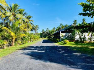 eine Straße vor einem Gebäude mit Palmen in der Unterkunft Baan Bang Kluai Resort บ้านบางกล้วย รีสอร์ท in Surat Thani
