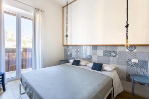 a bedroom with a bed and a large window at Canceddi Rooms in Palermo