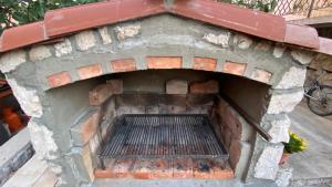 an outdoor brick oven with a grate in it at Apartment Brđanović in Cres
