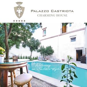 uitzicht op een zwembad en een tafel en een huis bij Palazzo Castriota in Alezio