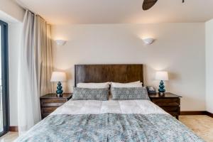 a bedroom with a large bed with two lamps at Unit 1014 at Croc's in Jacó