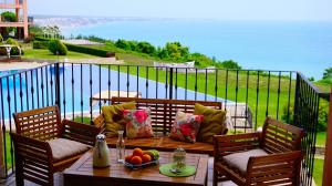 トポラにあるЛуксозни Апартаменти Калиакрия - Luxurious Apartments in Kaliakria Resortの水辺の景色を望むパティオ(テーブル、椅子付)