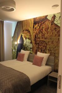 a bed in a room with a stone wall at Vakantiewoning Atuatuca in Tongeren