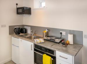 a small kitchen with a sink and a stove at The Bakehouse in Worthing