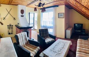 a living room with two chairs and a fireplace at Guesthouse Prachovské skály in Blata