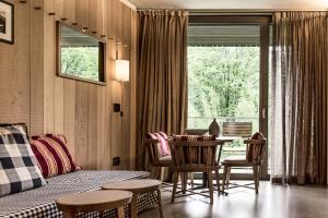 ein Wohnzimmer mit einem Bett, einem Tisch und Stühlen in der Unterkunft Eden Hotel in Bormio