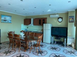 a kitchen and dining room with a table and a refrigerator at Zoremma Mini-hotel in Adler