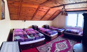 a room with three beds and a wooden ceiling at Guesthouse Prachovské skály in Blata