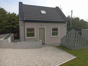 una pequeña casa con una puerta verde en un patio en Pier Road Cottage, Croagh Patrick en Westport