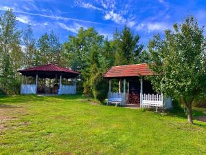 a gazebo with a white fence in a yard at Guesthouse Prachovské skály in Blata