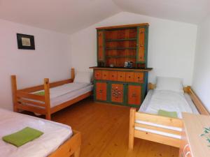 a room with two beds and a dresser in it at Wood Cabins in the heart of Transylvania in Colţeşti