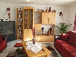 uma sala de estar com um sofá vermelho e uma mesa em Ana‘s Ferienwohnung em Furth im Wald