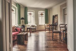 a living room with a couch and a table and chairs at OPERA Hostel in Erfurt