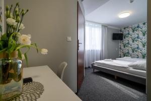 ein Zimmer mit einem Bett und einem Tisch mit Blumen darauf in der Unterkunft Noclegi Stop and Sleep in Zgorzelec