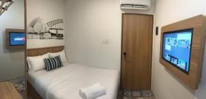 a bedroom with a bed and a flat screen tv at Casa Living Senayan Hotel in Jakarta +4 photos