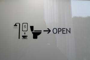 a bathroom with a sign that reads open at Casa Living Senayan Hotel in Jakarta