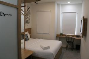 a bedroom with a bed and a desk and a window at Casa Living Senayan Hotel in Jakarta