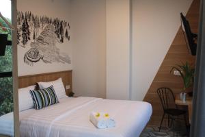 a bedroom with a bed with two towels on it at Casa Living Senayan Hotel in Jakarta