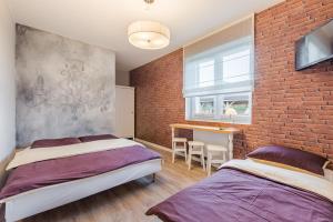 a bedroom with two beds and a brick wall at Morze u Moni in Karwieńskie Błoto Pierwsze