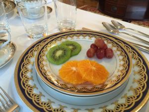 een bord met kiwi sinaasappels en fruit op een tafel bij Dartmouth House in Rochester