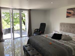 a bedroom with a bed and a chair and sliding glass doors at Love Room Villa Charlene in Massoins +100 photos