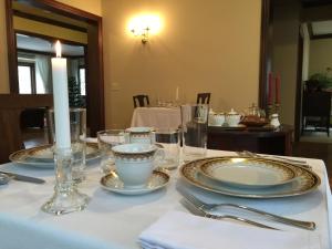 een tafel met borden en glazen en een kaars erop bij Dartmouth House in Rochester
