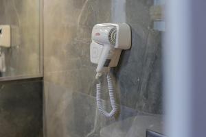 a hair dryer hanging on a wall in a bathroom at Villa Kristiano 21 in Sarandë