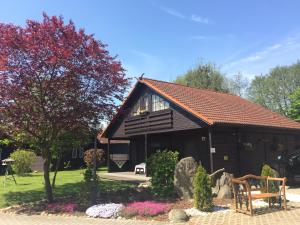a house with a bench and flowers in front of it at Hotel & Restaurant Zur Spreewälderin in Golßen