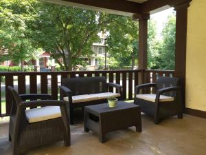 - une terrasse couverte avec des chaises en osier et une table dans l'établissement Dartmouth House, à Rochester