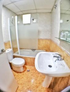 y baño con lavabo, aseo y bañera. en Apartamentos Resitur, en Sevilla