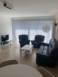 a living room with a couch and chairs and a table at Cap Horn 0205 in Koksijde