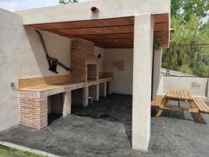 Cadalso de los VidriosにあるCasa Rural Mirando a Gredosの木製の屋根のレンガ造りのオーブン付きのパティオ