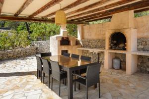 un patio con una mesa y un horno de pizza en Casa Olivo, en Sant Josep de sa Talaia