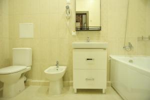 a bathroom with a toilet and a sink and a tub at Oblaka Hotel in Kurchatov