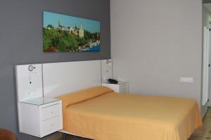 a bedroom with a bed and a painting on the wall at Apartamentos Resitur in Seville