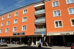 un edificio naranja con gente caminando delante de él en Hotel Vis à vis, en Lindau