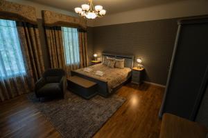 1 dormitorio con 1 cama y 1 silla en Roze Boutique Apartments, en Liepāja