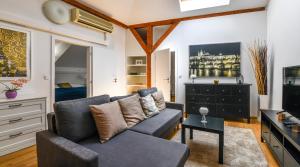 Una sala de estar con un sofá y un televisor en Apartments Rybná, en Praga