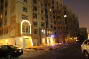 a large building with cars parked in front of it at White Moon Al Sadd in Doha