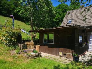 ein kleines schwarzes Haus in einem Garten in der Unterkunft Ferienhaus "Schleif" in Heiligkreuzsteinach