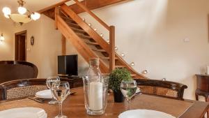 a table with glasses and a bottle of wine on it at VacationClub – Okrzei 1B Apartament 19 in Karpacz