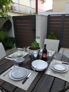 una mesa de madera con platos y copas y una botella de vino en Arxontia 2 en Kalamata