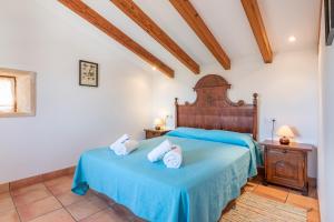 ein Schlafzimmer mit einem blauen Bett und zwei weißen Handtüchern in der Unterkunft Can Julia in Búger + 18 Fotos