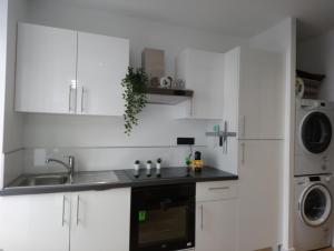 a white kitchen with a sink and a microwave at Appart Cosy Brest (Les 4 moulins) in Brest
