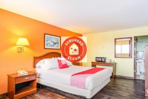 Cette chambre d'hôtel comprend un lit avec un panneau rouge de bienvenue. dans l'établissement OYO Hotel Downtown Peoria I-74, à Peoria