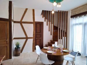 une salle à manger avec une table en bois et des chaises blanches dans l'établissement Jardin des Sens, la Rente d'Eguilly, à Éguilly