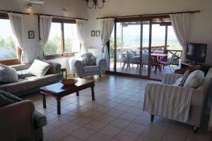 a living room with couches and a television and a table at Villa Pefka in Skiathos