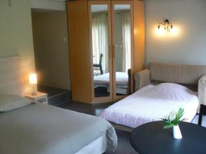 um quarto de hotel com duas camas e um espelho em Au Cèdre d'Or B&B em Lambersart